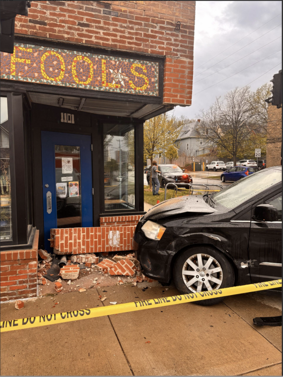 Front end of black minivan next to damage from collapsed column