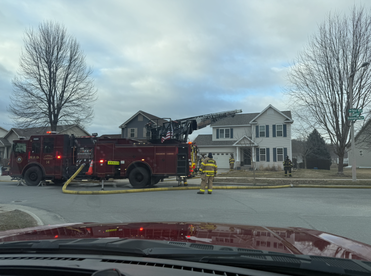 Ladder 14 with aerial ladder extended in front of home