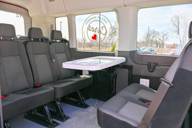 A collapsable table surrounded by seats in the back of the van