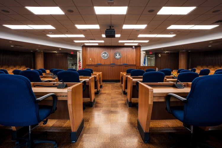 The Common Council chambers with row blue chairs facing a wooden dais 
