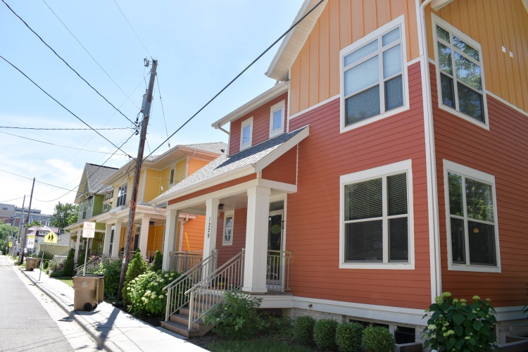 Three brightly colored houses on a Madison street