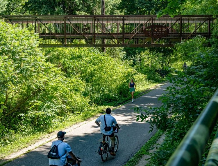 Two people on bikes and a runner on the Southwest Commuter Path