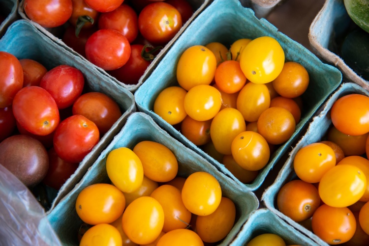 Several cardboard containers filled with yellow and red cherry tomatoes