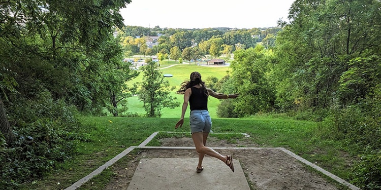 disc golfer throws from the hilltop at Elver Park
