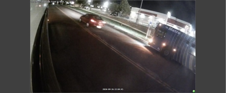 Traffic camera photo showing a red sedan involved in a hit-and-run crash.