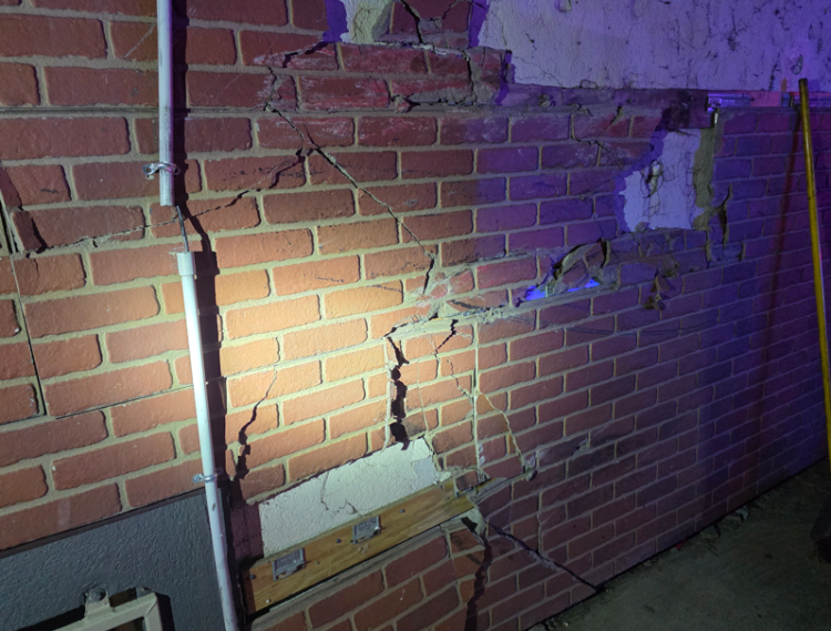 A brick building is damaged after a truck crashed into it.