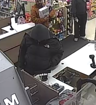 Photo of an individual wearing dark clothing with a hood covering their face