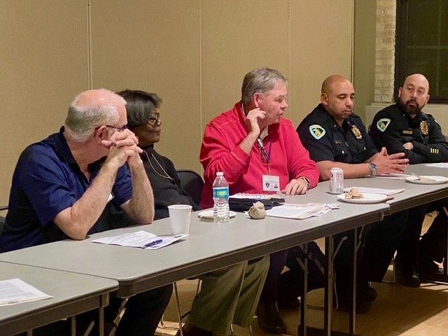 Members of the Community Police Advisory Boards talk with officers at a table.