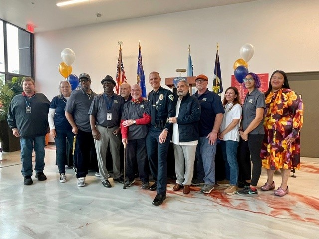 Members of the Community Policing Advisory Boards stand around newly sworn-in police chief John Patterson.