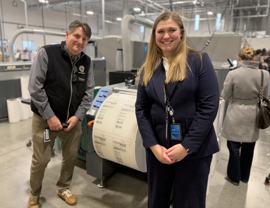 County Clerk McDonell & City Clerk Lydia McComas Standing in front of a ballot printer 