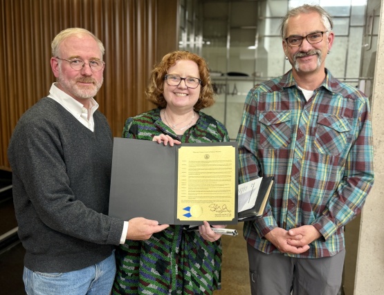 Kathleen Callen and Ben Lyman accepting the honorary resolution from Alder Tishler