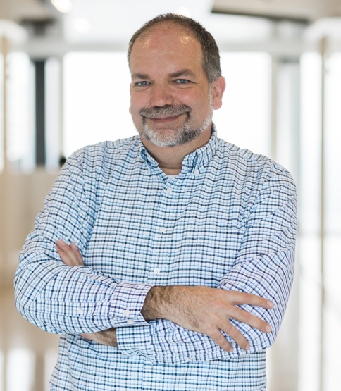 Christof Spieler standing in a hallway with arms crossed