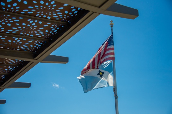 The U.S. and City of Madison flags on a pole with an awning in the foreground