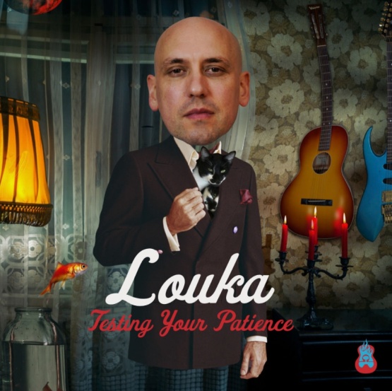 A man standing with an overly large head in a living room with a guitar hanging on the wall