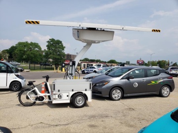 Electric cargo-bike and Chevy Bolt charging on solar charger