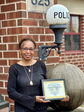 Retired Madison Police Department Lt. Stephanie Bradley Wilson stands smiling outside of the South District Police Station.