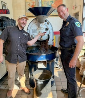 MPD Lieutenant Scott Reitmeier learns the intricacies of brewing coffee at Cargo Coffee with barista Max Johnson