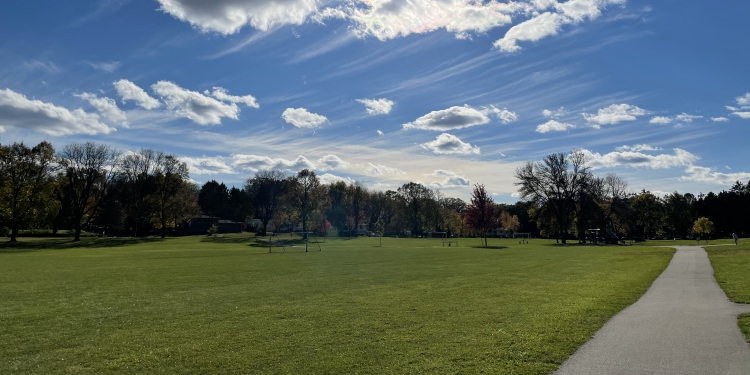 Long view of Rennebohm Park's grassy area and paved path. 