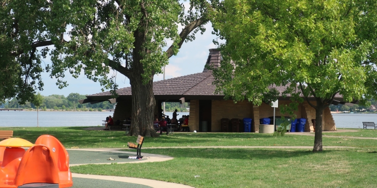 Park with grassy area and shelter overlooking the lake. 