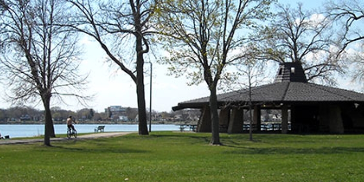 Park with grassy area and shelter overlooking the lake. 